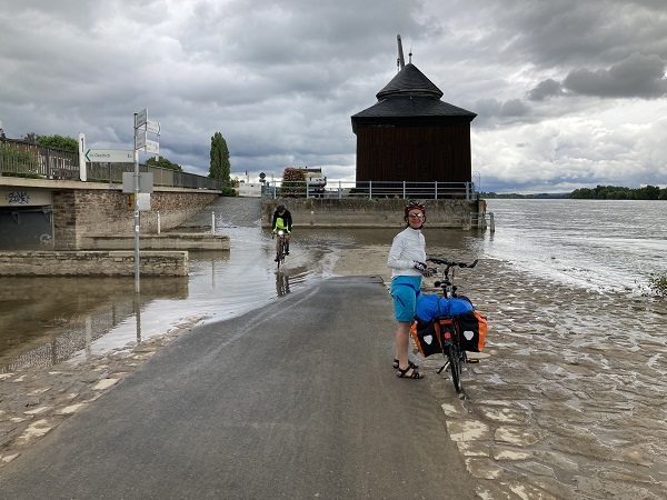 Radfahrer durchqueren Hochwasser am Rhein