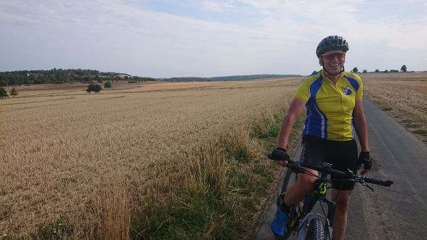 Thomas Brandl mit MTB vor trockenen Getreidefeldern