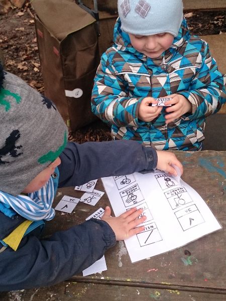 Zwei Kinder im Waldkindergarten sortieren Abbildungen