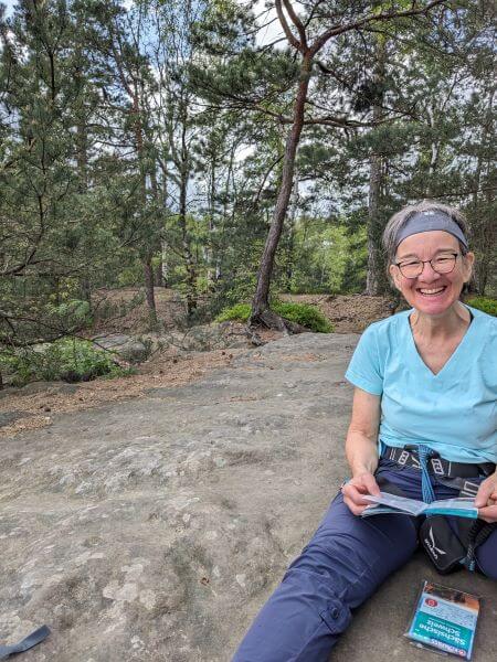 Frau sitzt auf Felsen